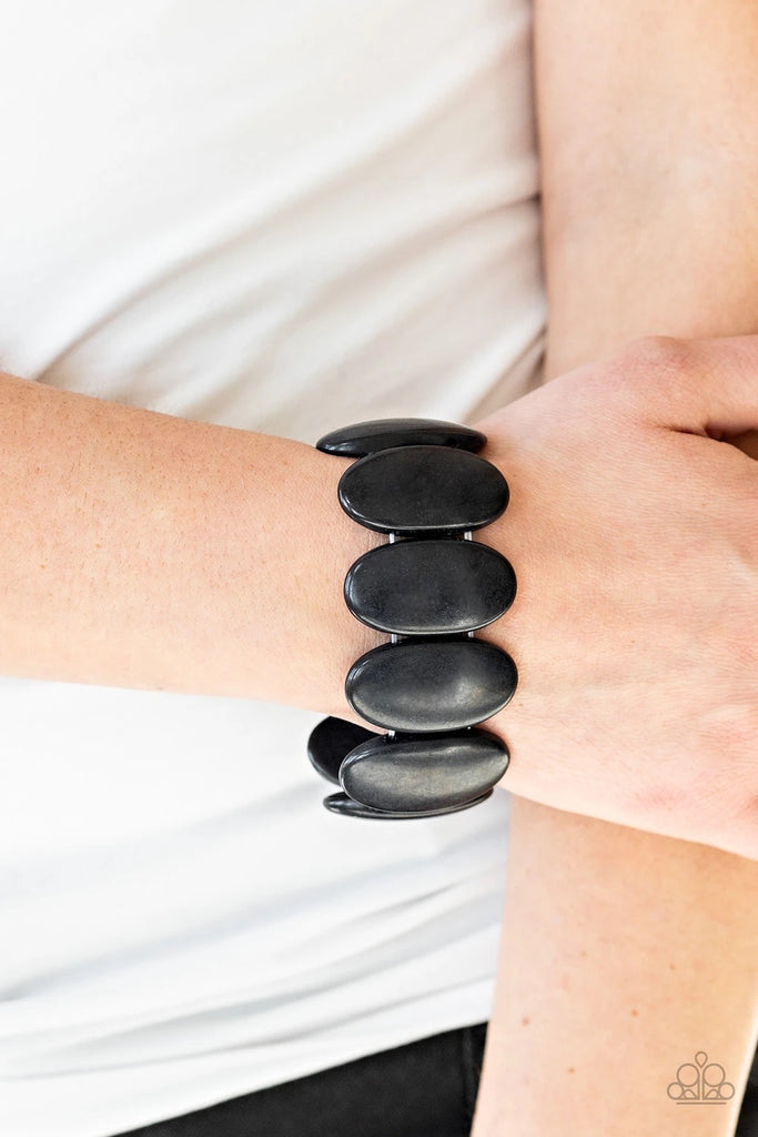 Chiseled into smooth ovals, earthy black stones are threaded along stretchy elastic bands around the wrist for an artisan inspired look.  Sold as one individual bracelet.