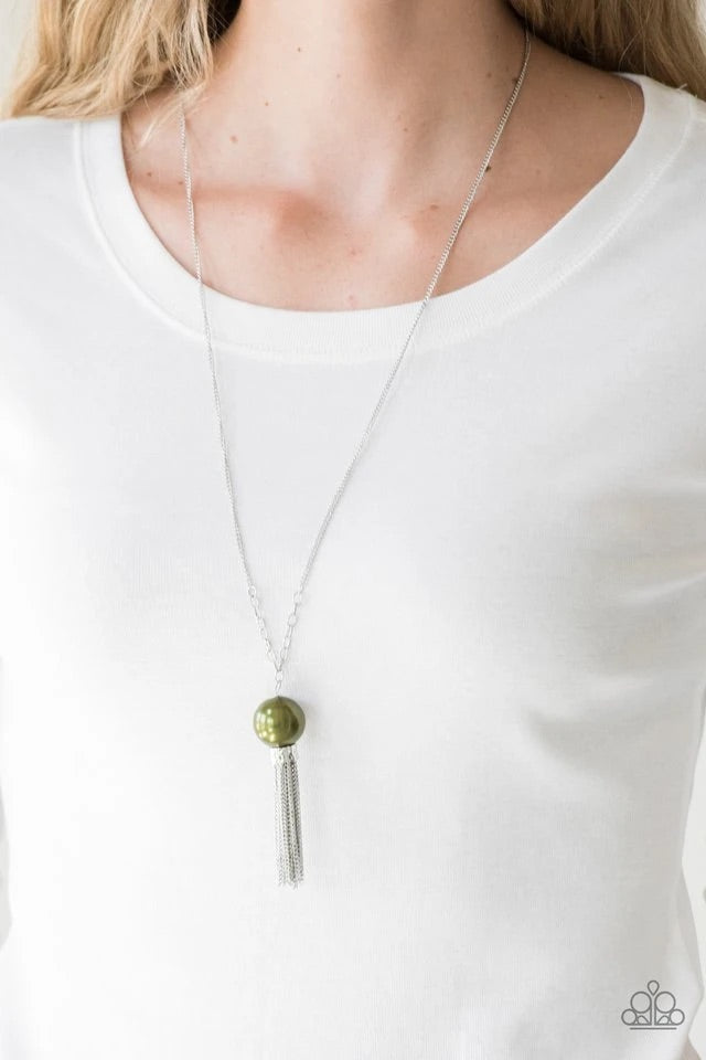 A dramatic pearly green bead swings from the bottom of an elegantly elongated silver chain. Featuring a hammered fitting, a silver tassel streams from the bottom of the colorful pendant for a whimsical finish. Features an adjustable clasp closure. Sold as one individual necklace. Includes one pair of matching earrings.