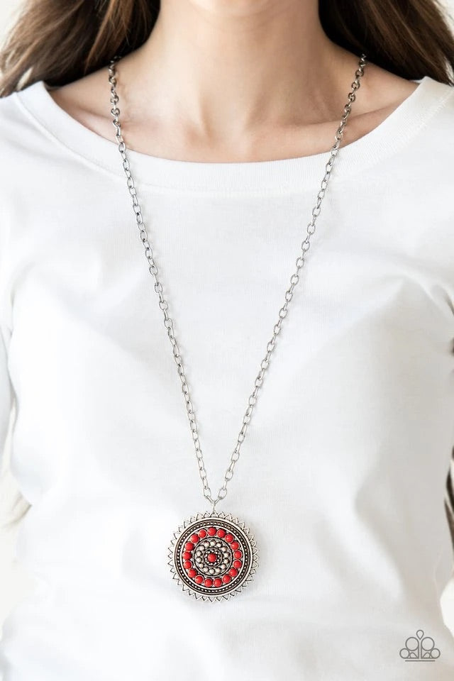 Radiating with shimmery sunburst details, a red beaded silver pendant swings from the bottom of a lengthened silver chain for a tribal inspired look. Features an adjustable clasp closure.  Sold as one individual necklace. Includes one pair of matching earrings.