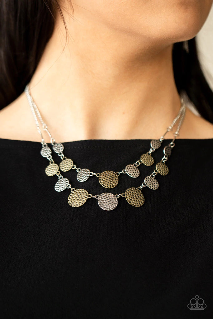 A double row of delicately hammered and dotted silver and brass discs gently lay across the collar. Gradually increasing in size, they connect to silver chains for a simple statement. Features an adjustable clasp closure.  Sold as one individual necklace. Includes one pair of matching earrings.  