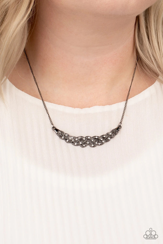 Encrusted in glassy white rhinestones, studded gunmetal bars braid into a bowing pendant below the collar for a refined fashion. Features an adjustable clasp closure.  Sold as one individual necklace. Includes one pair of matching earrings.