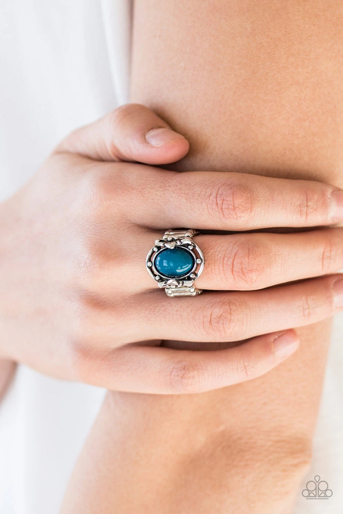 A polished blue bead is pressed into the center of a silver frame blooming with floral details for a whimsical finish. Features a stretchy band for a flexible fit.  Sold as one individual ring.