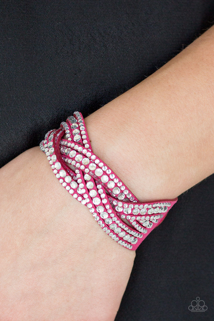 Varying in size, glassy white rhinestones are encrusted along interwoven pink suede bands, creating blinding shimmer across the wrist. Features an adjustable snap closure.  Sold as one individual bracelet.