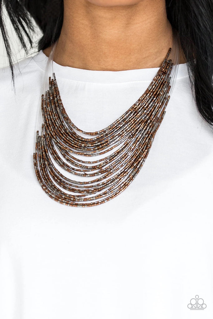 Strand after strand of metallic copper and gunmetal seed beads fall together to create a bold statement piece. Features an adjustable clasp closure.  Sold as one individual necklace. Includes one pair of matching earrings.