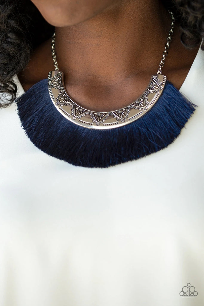 A plume of shiny blue thread flares out from the bottom of a silver half-moon frame stamped in tribal inspired patterns, creating a fierce fringe below the collar. Features an adjustable clasp closure.  Sold as one individual necklace. Includes one pair of matching earrings.