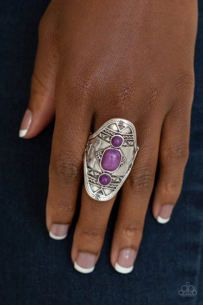 Three dainty purple stones dot the center of an ornate silver frame stamped and embossed in tribal inspired patterns for a seasonal look. Features a stretchy band for a flexible fit.  Sold as one individual ring.