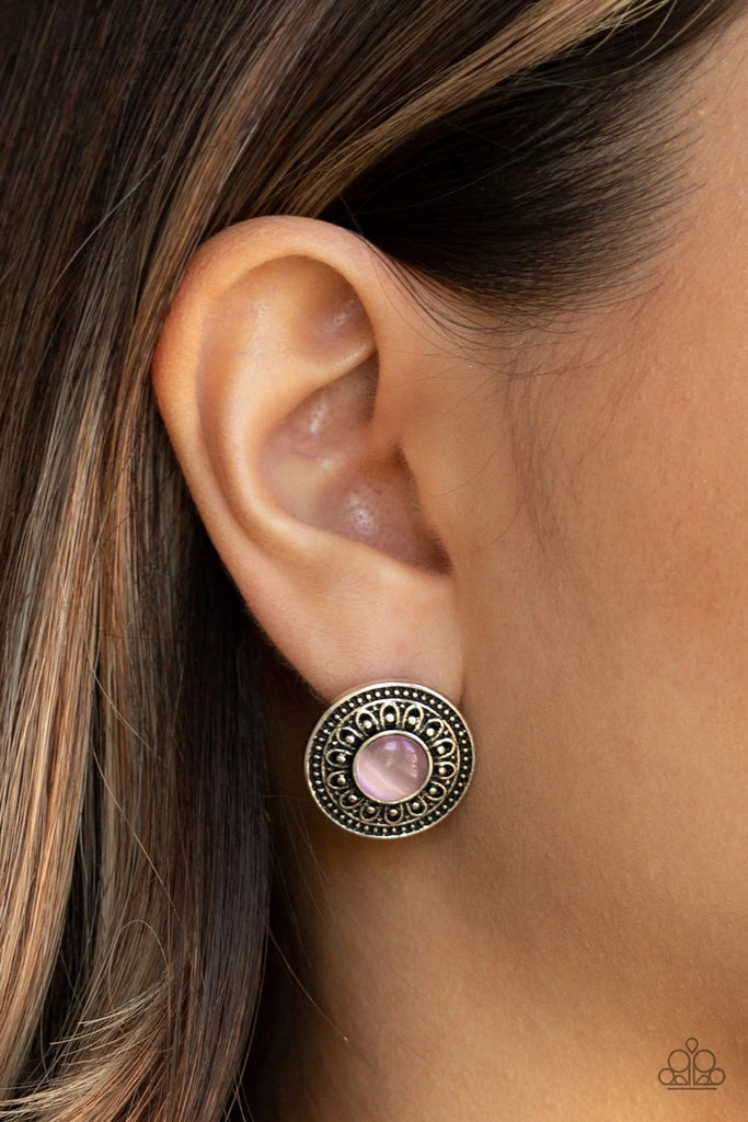 A glowing pink cat's eye stone is pressed into the center of a round silver frame embossed in blooming floral details for a seasonal vibe. Earring attaches to a standard post fitting.  Sold as one pair of post earrings.