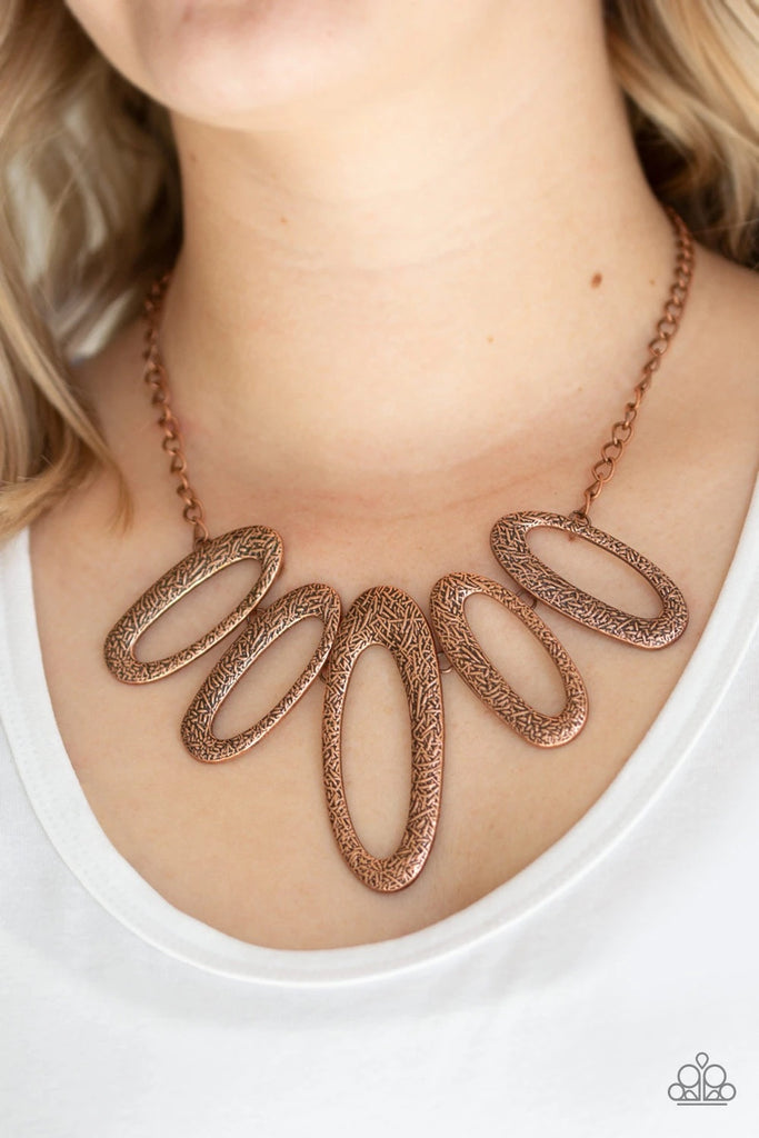 Embossed in radiating textures, asymmetrical copper ovals link below the collar in a fierce fashion. Features an adjustable clasp closure.  Sold as one individual necklace. Includes one pair of matching earrings.