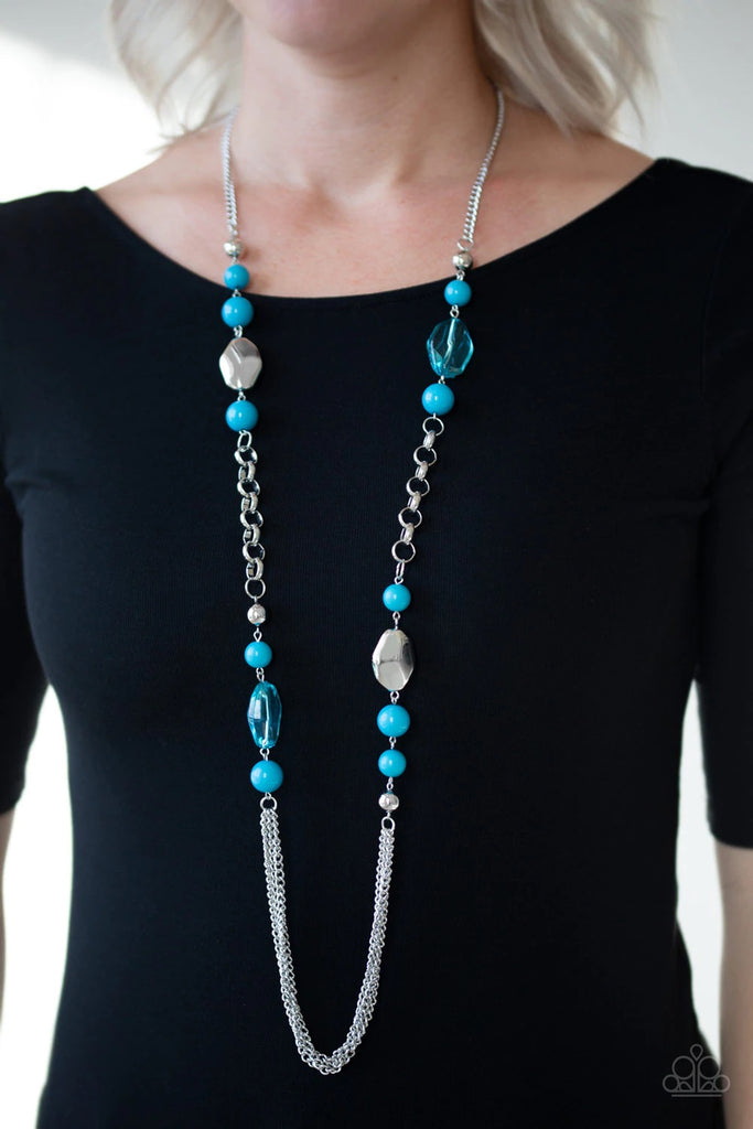 A collection of faceted silver, crystal-like blue, polished blue, and silver beads give way to layers of shimmery silver chains for a whimsical look. Features an adjustable clasp closure.  Sold as one individual necklace. Includes one pair of matching earrings.  