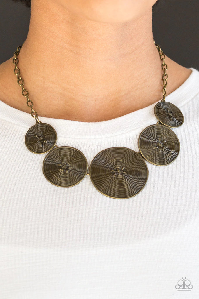 Radiating with spiraling textures, antiqued brass discs gradually increase in size as they link below the collar for a statement making look. Features an adjustable clasp closure.  Sold as one individual necklace. Includes one pair of matching earrings.