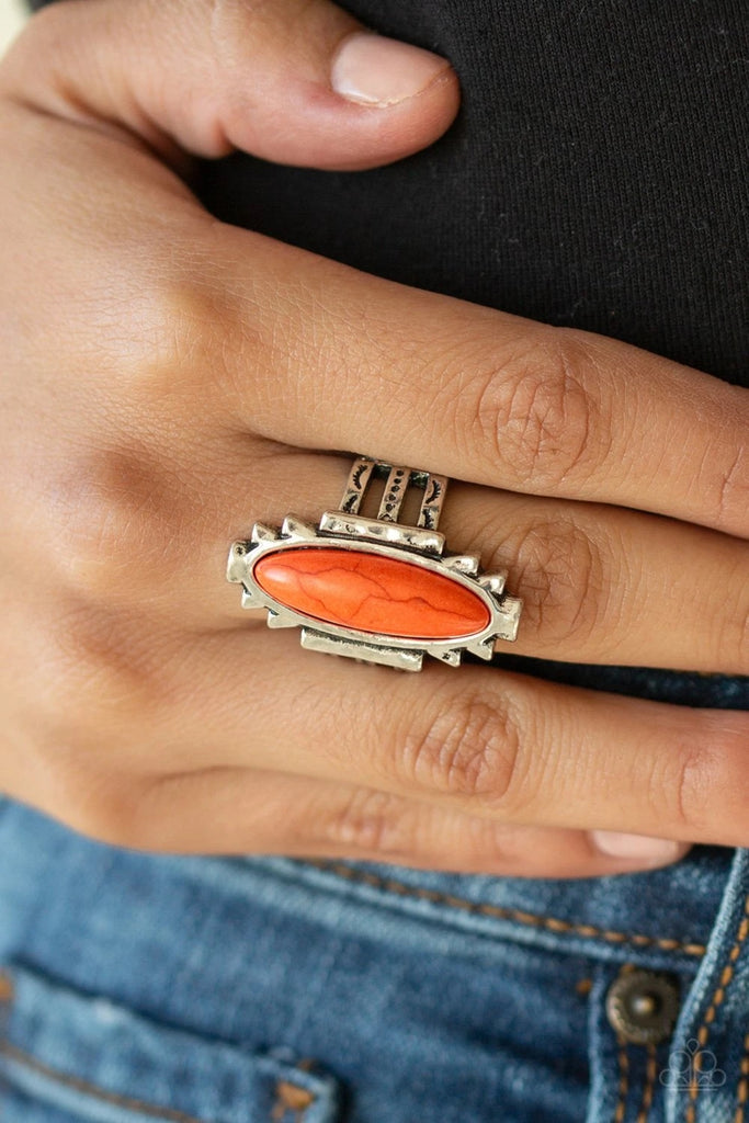 An oblong orange stone is pressed into the center of a geometric silver frame featuring a hammered finish for a seasonal flair. Features a stretchy band for a flexible fit.  Sold as one individual ring.