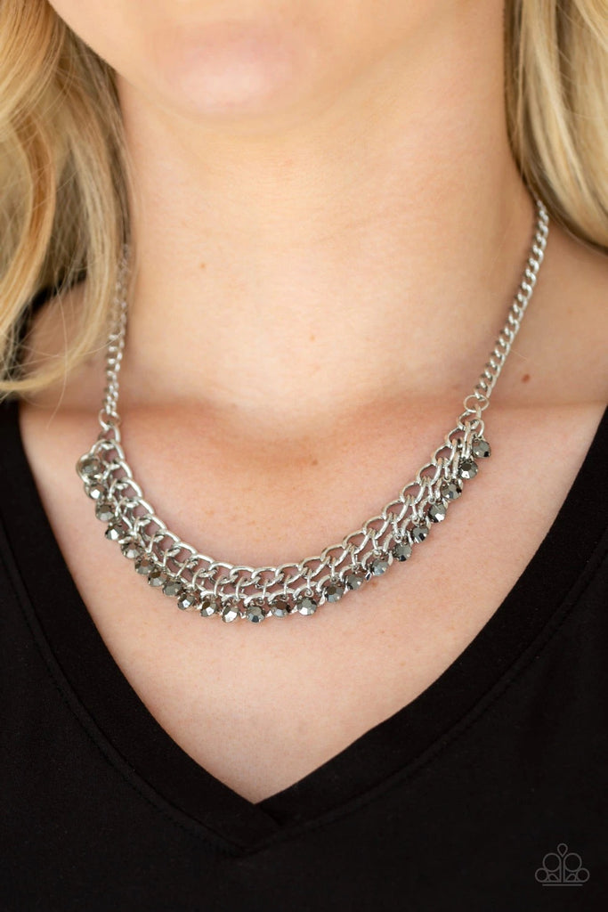 A fringe of glittery hematite rhinestones swings from the bottom of a bold silver chain below the collar for a fierce look. Features an adjustable clasp closure.  Sold as one individual necklace. Includes one pair of matching earrings.