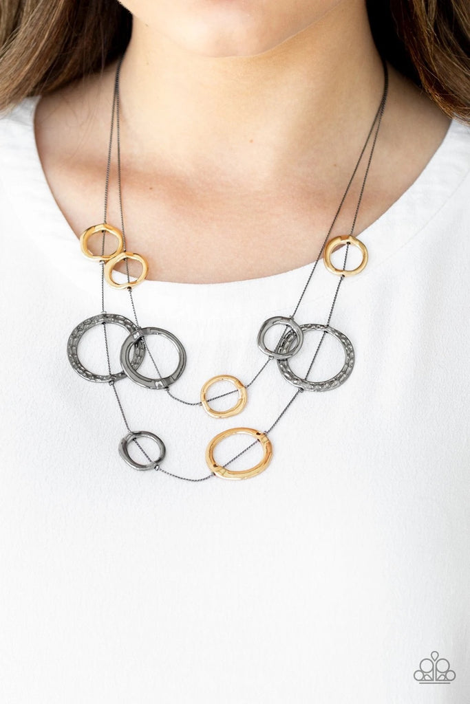 Featuring smooth and hammered finishes, a collection of asymmetrical gunmetal and gold rings are fitted in place along wire-like chains below the collar for a classically layered look. Features an adjustable clasp closure.  Sold as one individual necklace. Includes one pair of matching earrings.