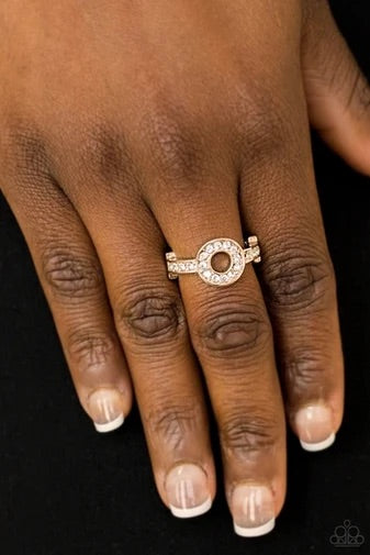 Encrusted in glassy white rhinestones, a dainty gold band attaches to a round frame, creating a sparkling centerpiece atop the finger. Features a dainty stretchy band for a flexible fit.  Sold as one individual ring.