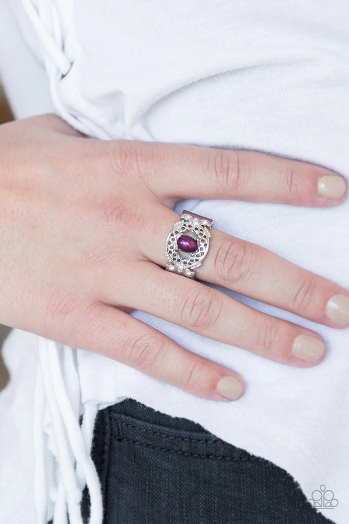 Dotted with glittery white rhinestones, an airy filigreed silver band arcs across the finger in a regal fashion. A pearly purple bead is pressed into the center of the band for a timeless finish. Features a stretchy band for a flexible fit.  Sold as one individual ring.