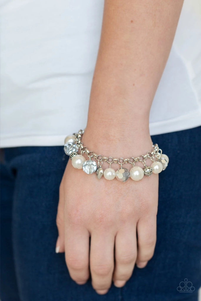 Featuring a dainty silver heart charm, rose charm, and ornate silver beads, a refined collection of white pearls and metallic crystal-like beads swing from the wrist for a flirtatious flair. Features an adjustable clasp closure.   Sold as one individual bracelet.