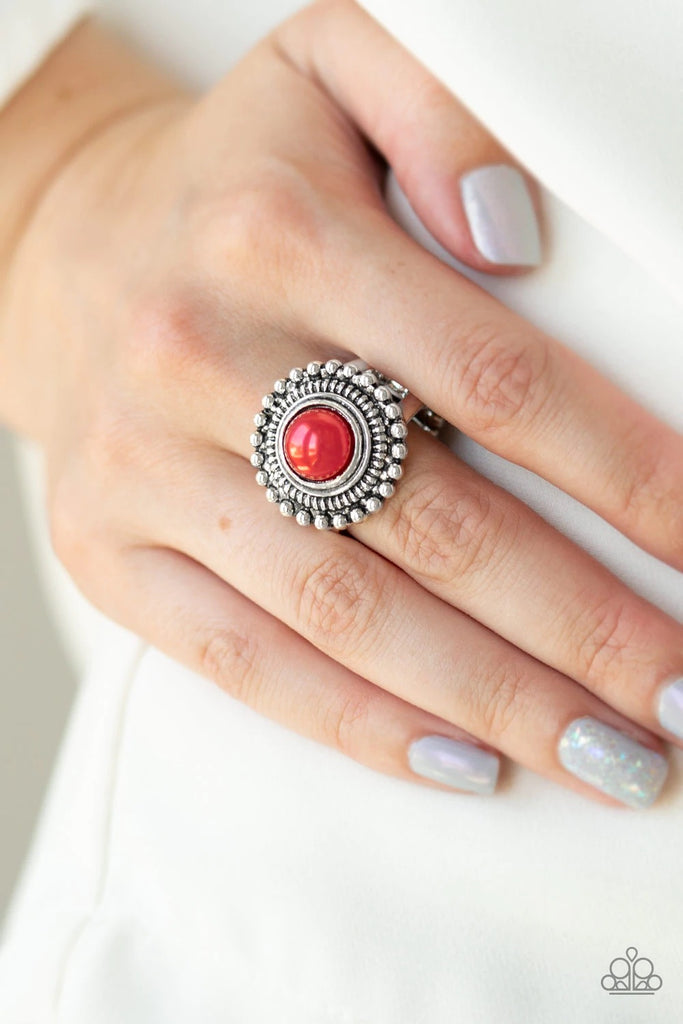 A pearly red bead is pressed into a round silver frame radiating in shimmery studded detail for a refined look. Features a stretchy band for a flexible fit.  Sold as one individual ring.