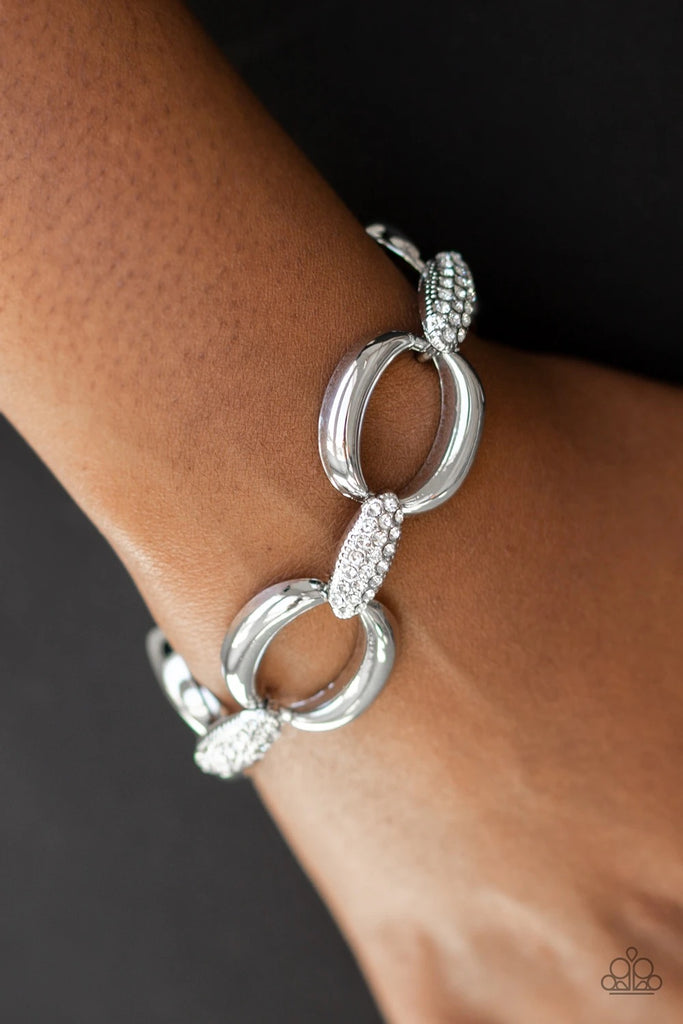 Bold silver links join with white rhinestone encrusted frames around the wrist for a fierce look. Features an adjustable clasp closure.  Sold as one individual bracelet.