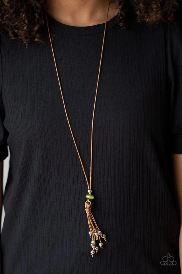 Infused with silver beaded tassels, shiny brown cording knots around glassy green beads at the bottom of a lengthened brown cord for a whimsical look. Features an adjustable sliding knot closure.  Sold as one individual necklace.