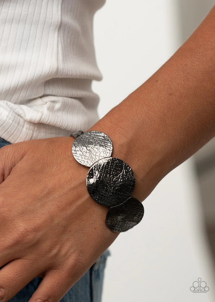 Three gunmetal discs etched in flawless texture and delicately hammered in ripples sit atop an open gunmetal cuff, creating a bold accent piece.  Sold as one individual bracelet.