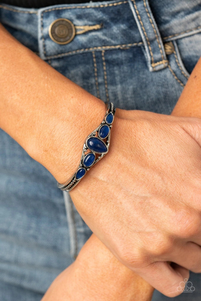 An earthy collection of glassy blue stones are encrusted across the front of a dainty silver cuff for a seasonal flair.  Sold as one individual bracelet.