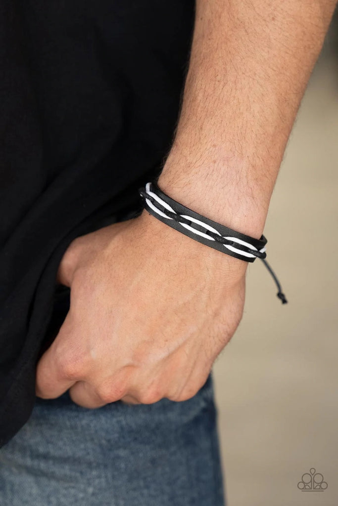 Black and white cording is interwoven across the top of a black leather band creating an edgy crisscrossed motion as it travels around the wrist. Features an adjustable sliding knot closure.  Sold as one individual bracelet.