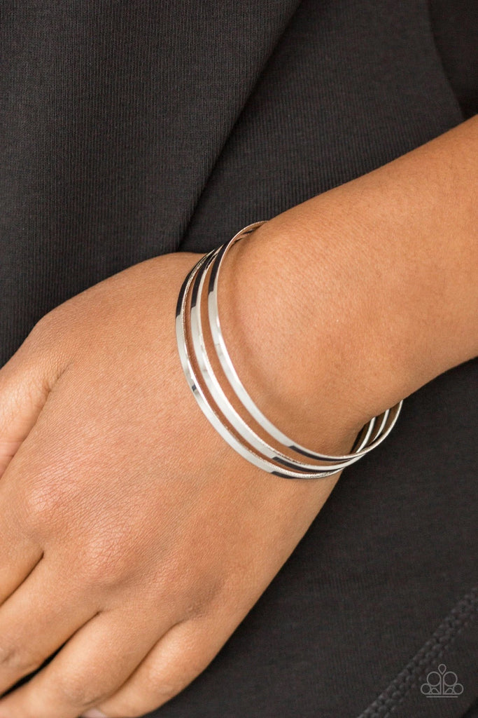Flat silver bars race across the wrist, coalescing into a sleek cuff for a casual look.  Sold as one individual bracelet.