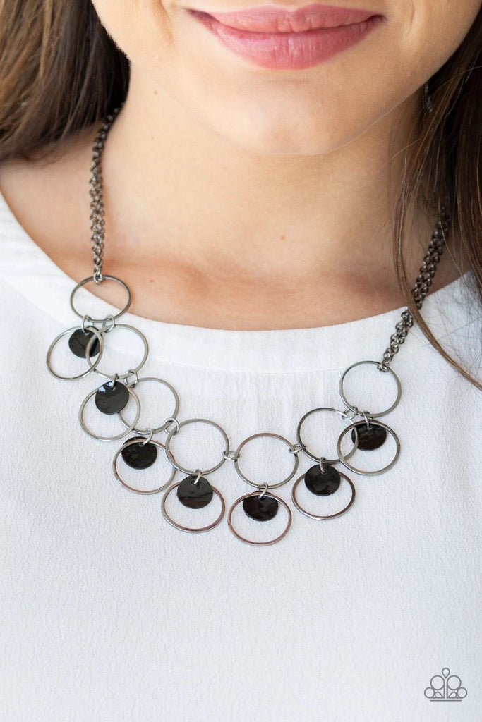 Infused with doubled gunmetal chains, a row of glistening gunmetal hoops connect below the collar. Black shell-like discs and airy gunmetal hoops swing from the bottom, creating a summery fringe. Features an adjustable clasp closure.  Sold as one individual necklace. Includes one pair of matching earrings.