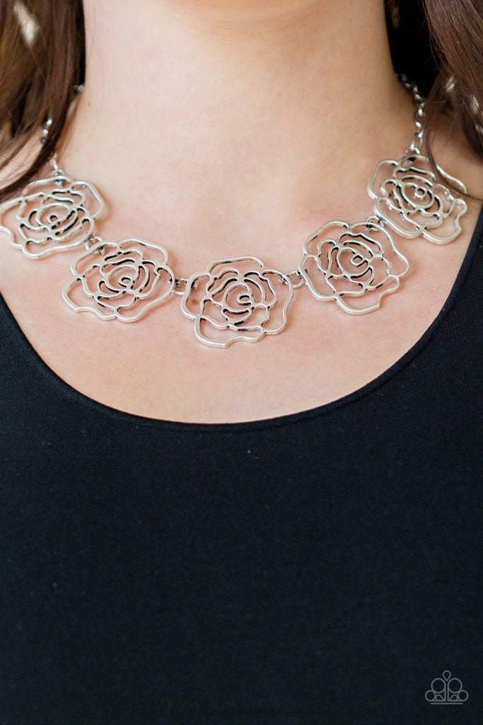 Brushed in a high-sheen finish, stenciled silver rosebuds link below the collar for a seasonal fashion. Features an adjustable clasp closure.  Sold as one individual necklace. Includes one pair of matching earrings.