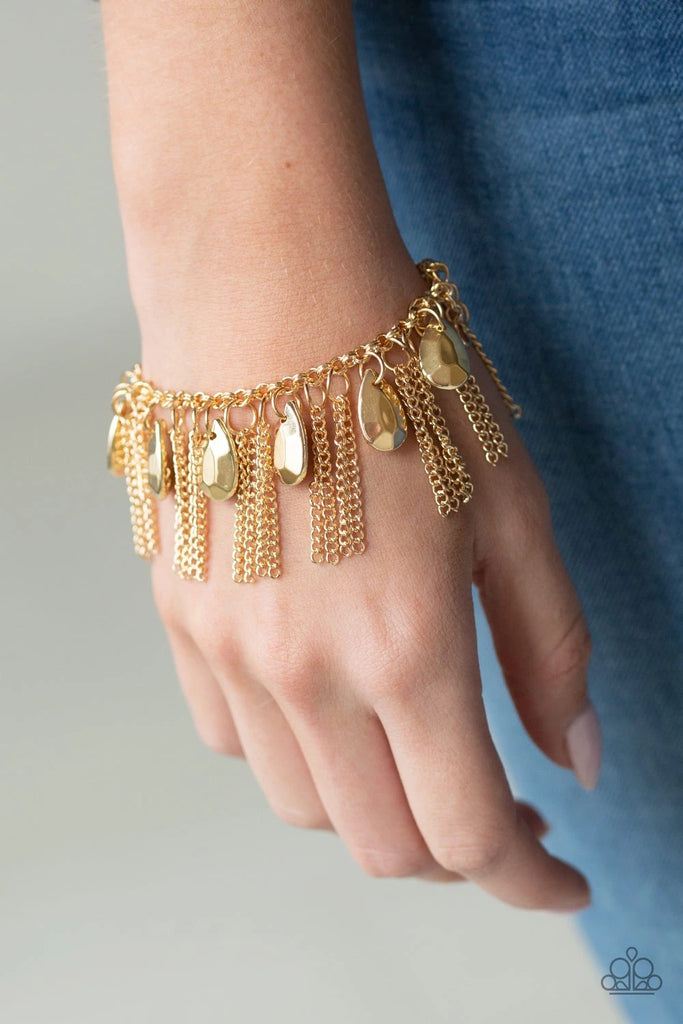 A row of faceted gold teardrops and free-falling gold chains swing from the wrist, creating a dramatic fringe. Features an adjustable clasp closure.  Sold as one individual bracelet.