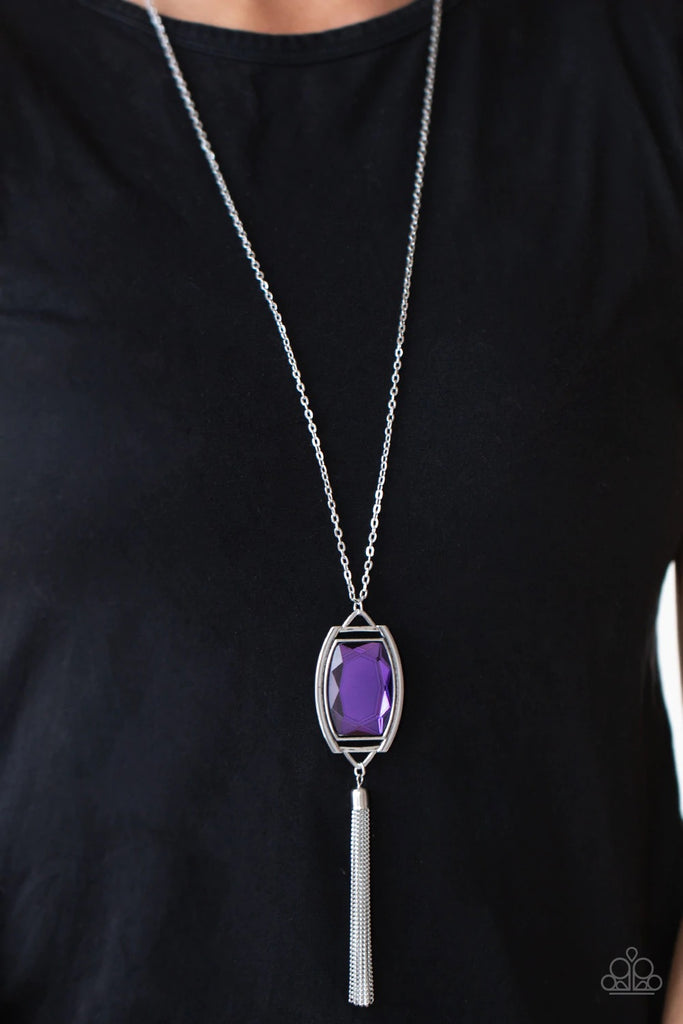 Encased in an antiqued silver frame, an oversized purple gem swings from the bottom of an ornate silver chain. A shimmery silver chain tassel swings from the bottom of the sparkly pendant, creating a regal talisman. Features an adjustable clasp closure.  Sold as one individual necklace. Includes one pair of matching earrings.