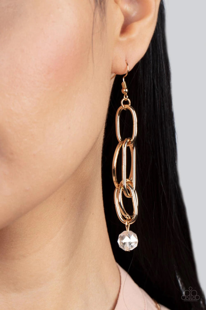 A collection of oval and round gold links, embellished with a faceted white bead suspended inside the bottom-most round frame, coalesce into a flirty charm as it sways from the ear. Earring attaches to a standard fishhook fitting.  Sold as one pair of earrings.