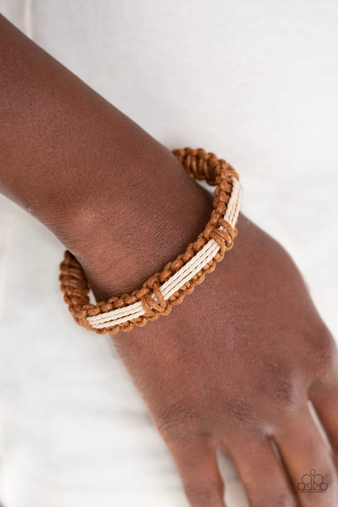 Braided brown cording knots around earthy strands of twine-like cording, creating an urban look around the wrist. Features an adjustable sliding knot closure.  Sold as one individual bracelet.  