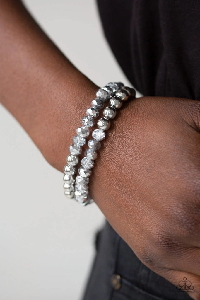 Dipped in a metallic shimmer, a collection of glittery crystal-like beads and shiny silver beads are threaded along two stretchy bands around the wrist for a refined look.  Sold as one set of two bracelets.