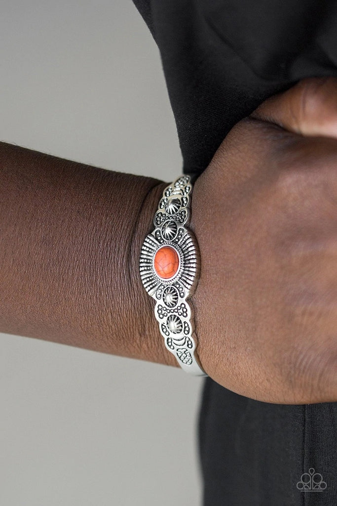 Dotted with a vivacious orange stone center, a dainty silver cuff radiating with shimmery southwestern inspired detail curls around the wrist for a seasonal look.  Sold as one individual bracelet.