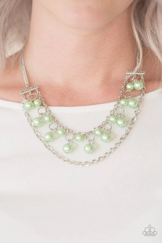 Attached to two floral fittings, rows of shimmery silver chains flank a pearly beaded strand below the collar. Dramatic green pearls and faceted crystal-like beads swing from the centermost strand for a refined finish. Features an adjustable clasp closure.  Sold as one individual necklace. Includes one pair of matching earrings.