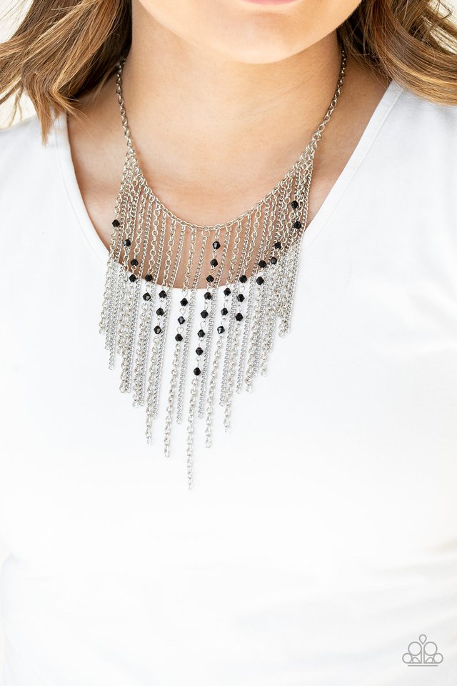 Varying in length, mismatched silver chains stream from the bottom of a classic silver chain. Faceted black crystal-like beads sporadically dot the free-falling chains, creating a statement-making fringe below the collar. Features an adjustable clasp closure. Sold as one individual necklace. Includes one pair of matching earrings.