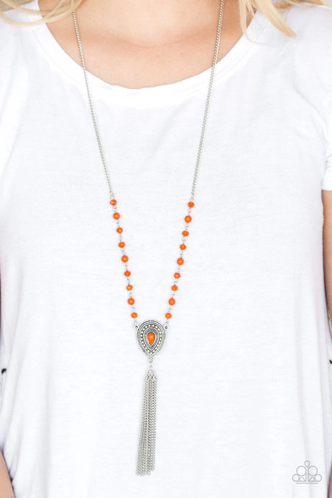 Polished and crystal-like orange beads trickle along a shimmery silver chain, giving way to a glistening teardrop pendant. Infused with studded detail and a matching orange beaded center, the ornate pendant gives way to a shimmery silver chain tassel for a wanderlust finish. Features an adjustable clasp closure.  Sold as one individual necklace. Includes one pair of matching earrings.
