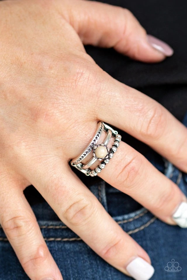 A trio of studded, smooth, and tribal stamped silver bands layer across the finger, coalescing into an airy frame. A dainty Soybean bead is pressed into the center of the shimmery layers for a perfect pop of color. Features a stretchy band for a flexible fit. Sold as one individual ring.