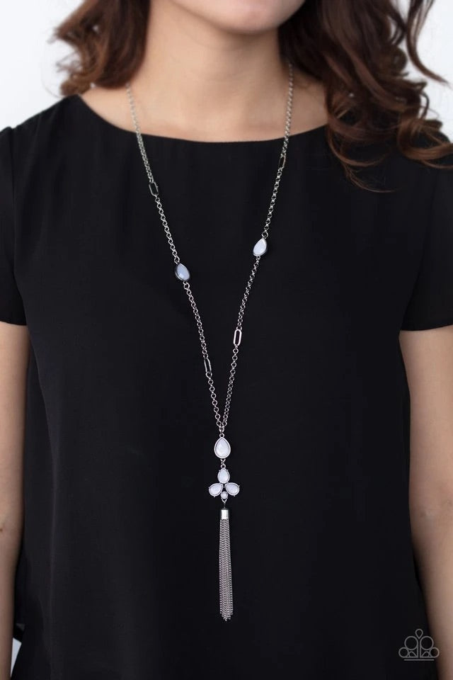 A cluster of dewy white teardrop beads coalesces at the bottom of a lengthened silver chain. Matching beads embedded in airy silver frames dot the chains that climb the chest, bringing an extra pop of color to the whimsical design. A glistening silver tassel cascades from the bottom of the colorful pendant, creating ethereal movement. Features an adjustable clasp closure.  Sold as one individual necklace. Includes one pair of matching earrings.