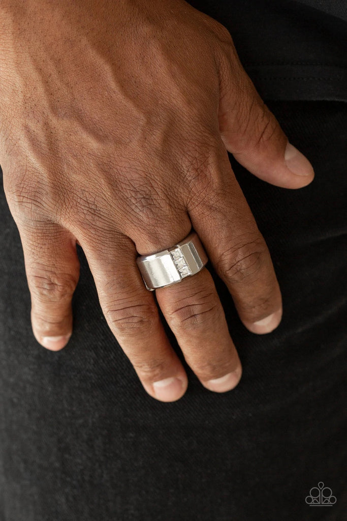 A single row of square-cut white rhinestones stack down the center of a thick silver band. Features a stretchy band for a flexible fit.  Sold as one individual ring.