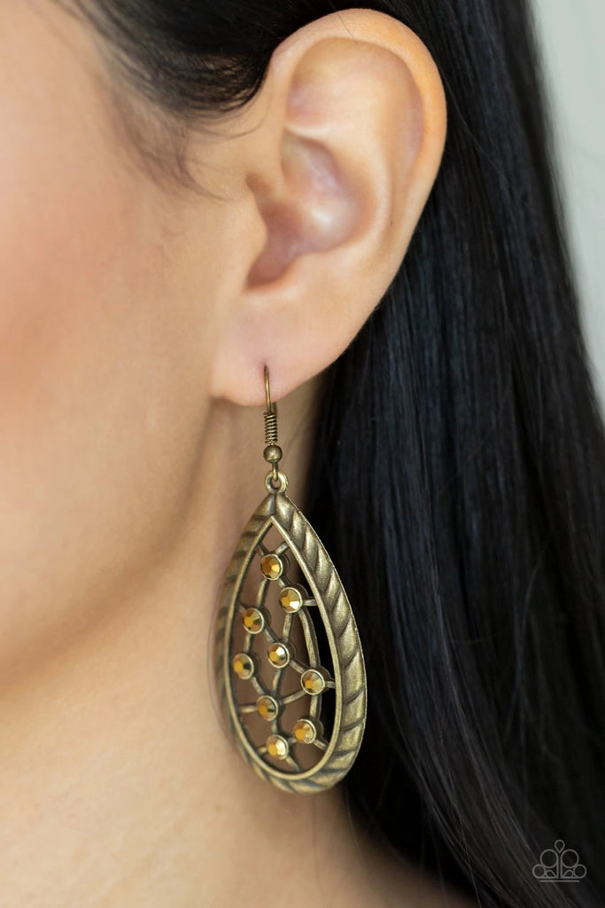 A gritty collection of dainty aurum rhinestones adorn hammered brass bars streaking across the airy center of an antiqued textured teardrop, creating a rustic fashion. Earring attaches to a standard fishhook fitting.  Sold as one pair of earrings.