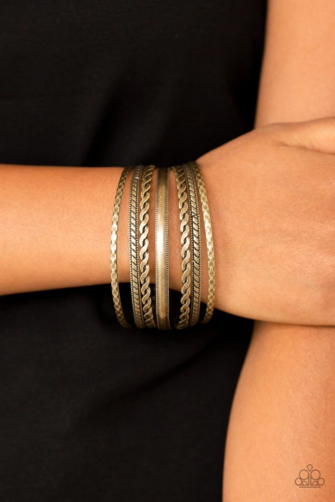 Featuring an array of tribal inspired textures, mismatched brass bangles stack across the wrist for a seasonal look.  Sold as one set of seven bracelets.