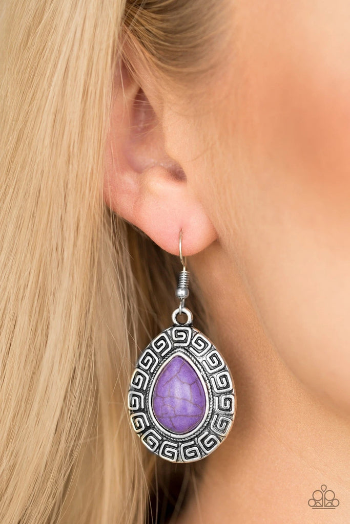 Chiseled into a tranquil teardrop, a vivacious purple stone is pressed into the center of a silver frame embossed in spiraling patterns for a tribal look. Earring attaches to a standard fishhook fitting.  Sold as one pair of earrings.