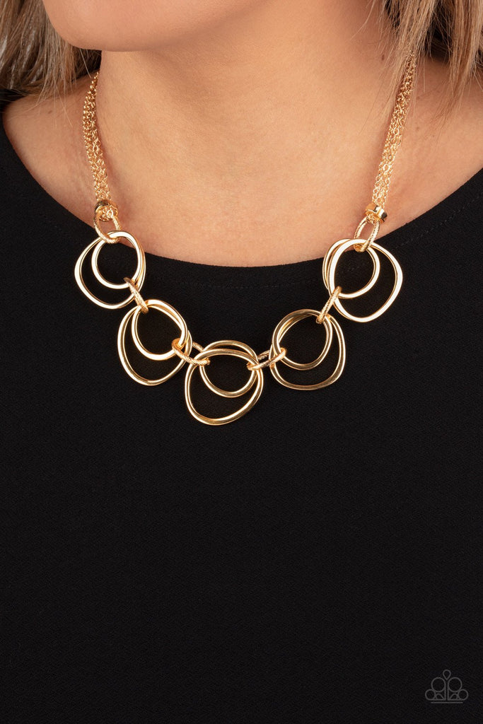 Infused with decorative gold links, an asymmetrical assortment of gold rings delicately link below the collar for a refined flair. Features an adjustable clasp closure.  Sold as one individual necklace. Includes one pair of matching earrings.