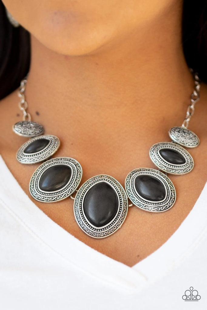 Gradually increasing in size near the center, earthy black stones are pressed into textured silver frames below the collar for a tribal inspired look. Features an adjustable clasp closure.  Sold as one individual necklace. Includes one pair of matching earrings.