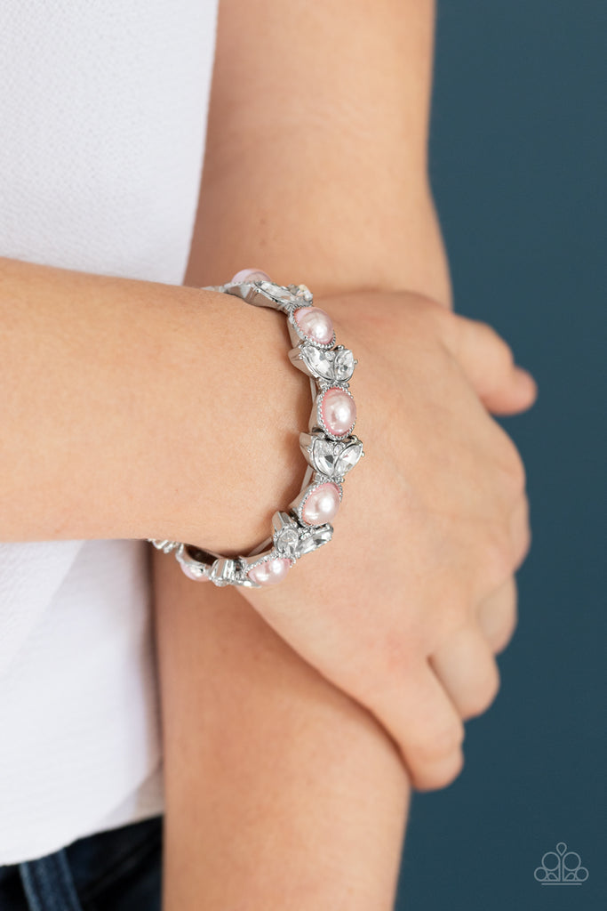 Encrusted in dazzling white rhinestones and an oversized pink pearl, leafy silver frames are threaded along stretchy bands around the wrist for a timeless look.  Sold as one individual bracelet.