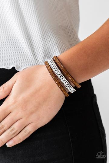 Rows of glassy topaz and white rhinestones and a shimmery silver chain are encrusted along brown suede bands for a sassy look. Features an adjustable snap closure.  Sold as one individual bracelet.